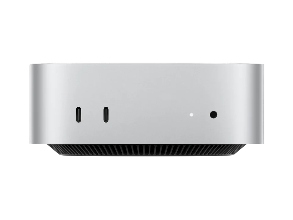 Mac mini argent vu de face : deux ports USB-C et une prise casque sur la façade, grille d'aération noire sous le boîtier.