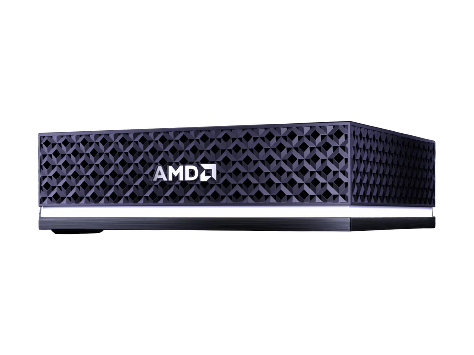 Mini-PC AMD Ryzen AI Halo vu de trois quarts : boîtier noir aux parois en treillis de losanges, logo AMD en façade, bande lumineuse blanche à la base.