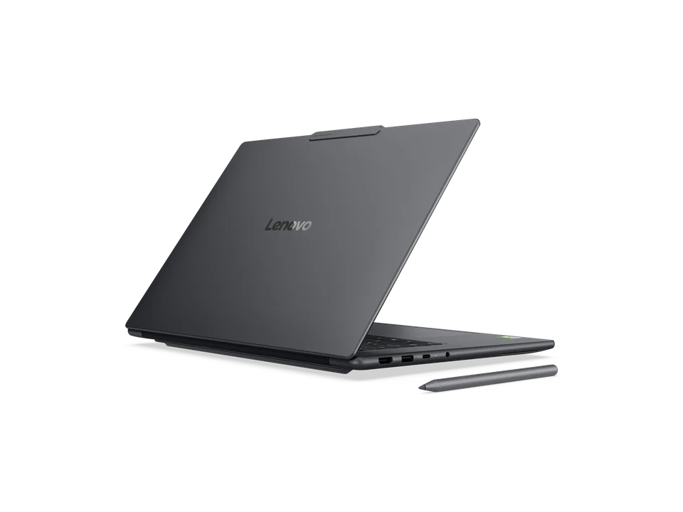 PC portable Lenovo Yoga Pro 9n gris ouvert, vu de dos et de trois quarts : capot gris marqué Lenovo, ports sur le flanc, stylet posé devant.